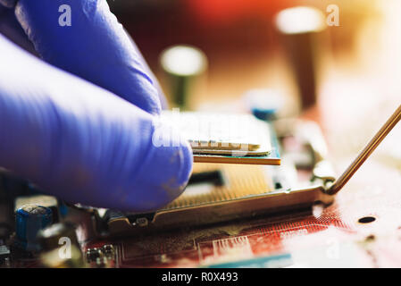 Computer forensics investigator installing old cpu on computer motherboard to recover machine and lost data, close up of hand Stock Photo