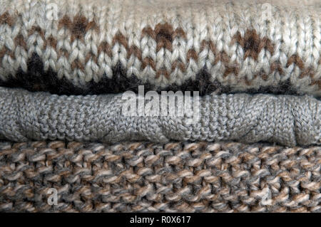 stack of natural colored woolen pullovers in wardrobe Stock Photo