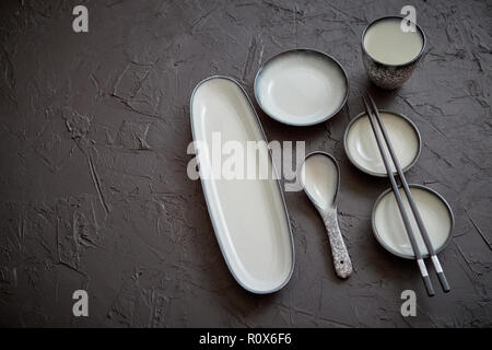 Set of empty ceramic dishes for sushi and rolls on a black stone table Stock Photo