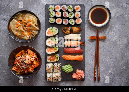 Various kinds of sushi placed on black stone board Stock Photo