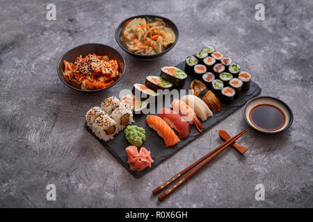 https://l450v.alamy.com/450v/r0x6gh/various-kinds-of-sushi-placed-on-black-stone-board-r0x6gh.jpg