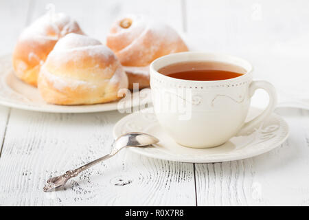 Cup of tea and small apple roses shaped pies. Sweet apple dessert pie Stock Photo