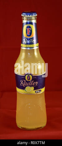 Reading, United Kingdom - May 02 2015:   A bottle of Fosters Radler, a lager shandy made with cloudy lemonade by Australian Brewery Fosters Stock Photo