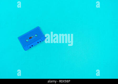 Retro blue plastic audio cassette laying on the green metal table Stock Photo