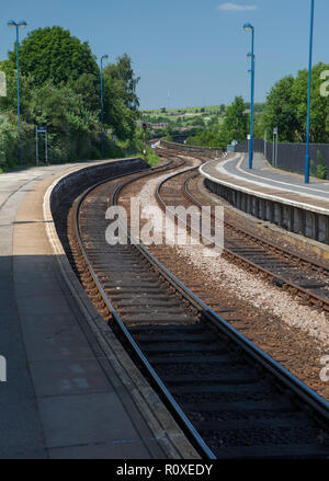 View from the platform of Penistone railway station in South yorkshire showing the curving railway tracks in bright Summer sunshine Stock Photo