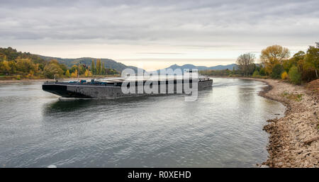 Navigation vessel with reduced shipload on river Rhine with low water level, caused by drought 2018, by Unkel view to Siebengebirge, Germany Stock Photo