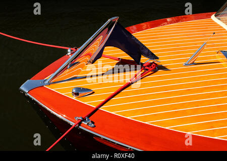 Bow of vintage wooden boat with crome reflecting wood stripes - red and yellow Stock Photo