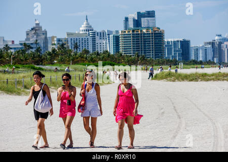 Miami Beach Florida,public beach,ocean front,Asian woman female women,young adult,group,beachcomber,walking,girlfriends,skyline,dunes,sand,Spring Brea Stock Photo