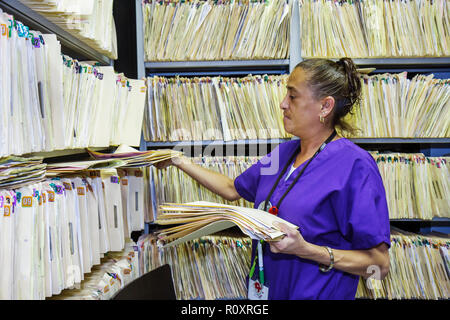 Miami Florida,Borinquen Health Care Center,clinic,optometrist office,patient records,manila folders,shelf shelves,privacy,confidentiality,Hispanic wom Stock Photo