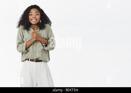 Cannot wait be nominated for promotion. Portrait of charming excited and delighted happy cute female with curly hair and dark skin rubbing hands with await and smiling feeling amused and upbeat Stock Photo