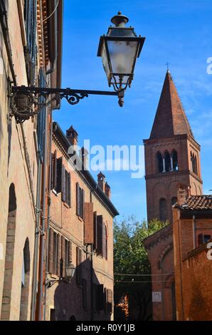 Ferrara, eine alte Stadt in der Emilia-Romagna in Italien: Straßenlaterne und Kirche in der Altstadt Stock Photo