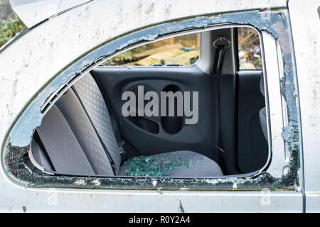 Automobile has been broken into with smashed glass all over the rear seats, victim of a car crime and theft. Stock Photo