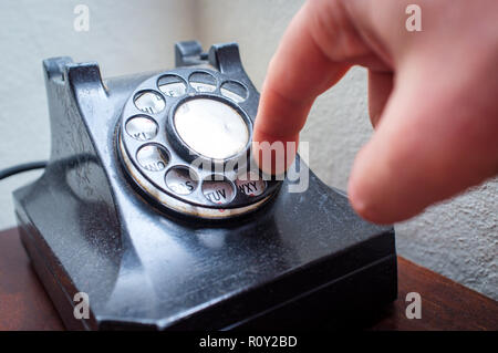 Old vintage rotary dial telephone on wooden desk Stock Photo