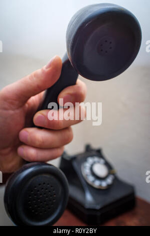 Old vintage rotary dial telephone on wooden desk Stock Photo