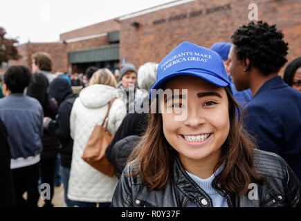 Young woman wears an 'Immigrants Make America Great' hat outside of a venue that former president Barack Obama is speaking at in Milwaukee, Wisconsin. Stock Photo