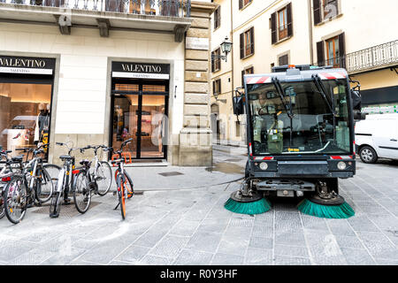 Florence, Italy - August 31, 2018: Mounted street sweeper machine, truck with brushes cleaning, brushing empty road in Firenze, Italian city, with nob Stock Photo