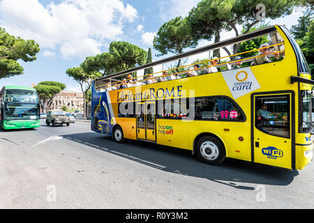 Rome, Italy - September 4, 2018: Vatican and Roma yellow tour double decker hop on, hop off bus with Colosseum amphitheatre in background, people on b Stock Photo