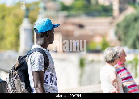 Rome, Italy - September 5, 2018: African black male, man, immigrant standing on street, road with Italian people, senior couple in Roma Stock Photo