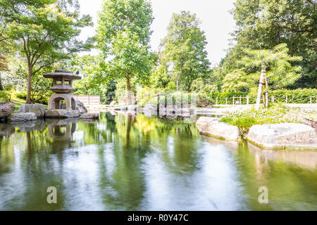 Kyoto Japanese Garden in Holland Park, green summer peaceful zen lake pond, stone lantern in London, UK, nobody, sunny day Stock Photo