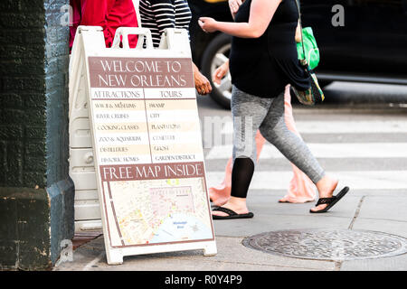 New Orleans, USA - April 22, 2018: Placard tourism sign for tourist information center on sidewalk in Louisiana town, city, people walking on street Stock Photo