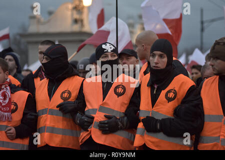 November 11, 2017 - Warsaw, mazowieckie, Poland - Masked nationalists in orange jackets seen forming a barrier on the Independence Day during the demonstration.Last year about 60,000 people took part in the nationalist march marking Poland's Independence Day, according to police figures. The march has taken place each year on November 11th for almost a decade, and has grown to draw tens of thousands of participants, including extremists from across the EU.Warsaw's mayor Hanna Gronkiewicz-Waltz has banned the event. Organizers said they would appeal against the decision, insisting they wo Stock Photo
