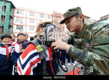 Handan, China's Hebei Province. 8th Nov, 2018. A fire fighter shows a student how to wear an oxygen mask in Handan, north China's Hebei Province, Nov. 8, 2018. Fire safety awareness campaigns have been held across China in the run-up to the National Fire Prevention Day on Nov. 9. Credit: Zhu Xudong/Xinhua/Alamy Live News Stock Photo