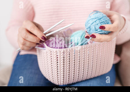 Knitting baby things, close up colored clew in hand Stock Photo
