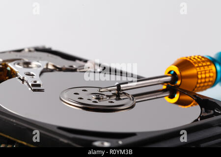 Hard disc drive disassembling close up. Repairman opening hdd for recovery information, service center and electronics repair concept Stock Photo