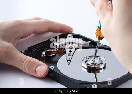 Hard disc drive disassembling close up. Repairman opening hdd for recovery information, service center and electronics repair concept Stock Photo