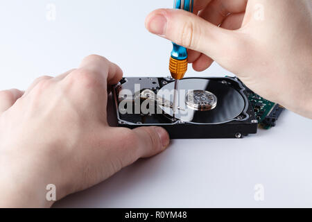 Hard disc drive disassembling close up. Repairman opening hdd for recovery information, service center and electronics repair concept Stock Photo