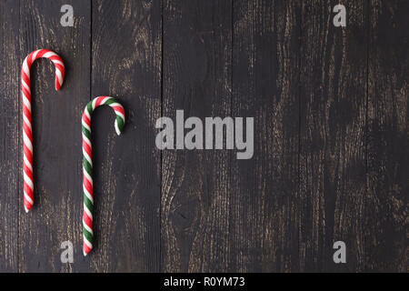 Candy canes on wooden boards - holidays background Stock Photo