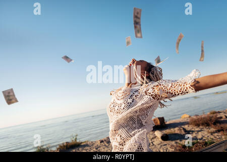 Successful prosperous freelancer throwing her money in the air Stock Photo