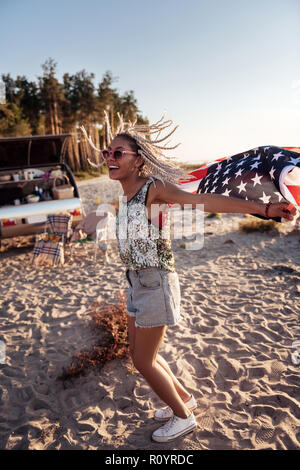 Stylish woman with dreadlocks feeling wild and free traveling in trailer Stock Photo