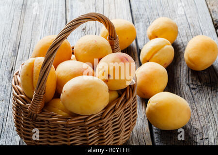 Big ripe apricots in basket. Juicy, soft fruit, resembling a small peach Stock Photo