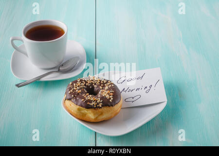 Donuts on saucer with note Good morning Stock Photo