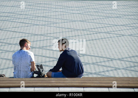 Novosibirsk 07-31-2018. Two young guys are sitting on a park bench. Stock Photo