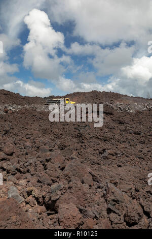 Pahoa, Hawaii - Trucks traverse a road being built on cooled lava from the 2018 eruption of the Kilauea volcano. This lava flow destroyed over 700 hom Stock Photo