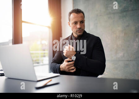 Pensive businessman working with a laptop in office Stock Photo