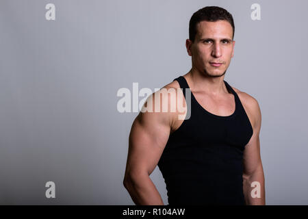 Studio shot of young muscular Persian man wearing sleeveless aga Stock Photo