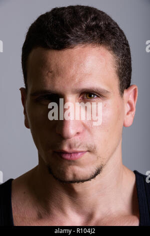 Face of young muscular Persian man against gray background Stock Photo