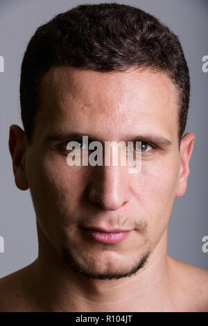 Face of young muscular Persian man against gray background Stock Photo