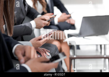 close up.business team using their smartphones in the workplace Stock Photo