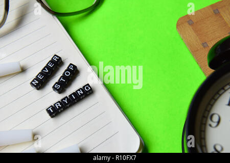 Never stop trying message written on wooden blocks. education and motivation concepts. Cross processed image on green Background Stock Photo
