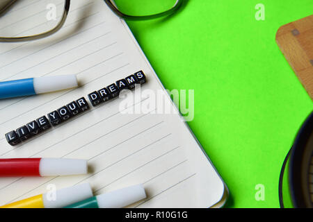 Live your dreams message written on wooden blocks. education and motivation concepts. Cross processed image on green Background Stock Photo