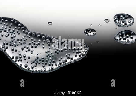 Close up of spilled fizzy liquid on reflective surface Stock Photo