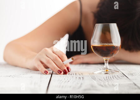 Drunk woman holding an alcoholic drink, Focused on the drink Stock Photo