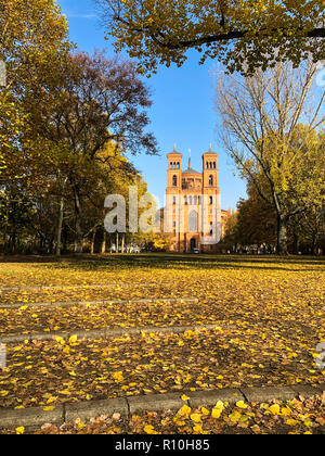 park in autumn and  St. Thomas Church in Berlin, Kreuzberg Stock Photo