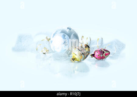 Ornate Christmas baubles and ribbon on white surface Stock Photo