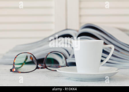 Stack of magazines and newspaper open page on table Stock Photo