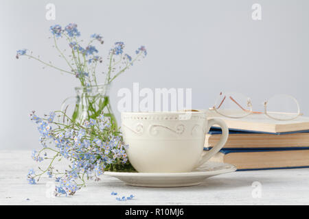 Forget-me-nots flowers on book, on wooden background Stock Photo